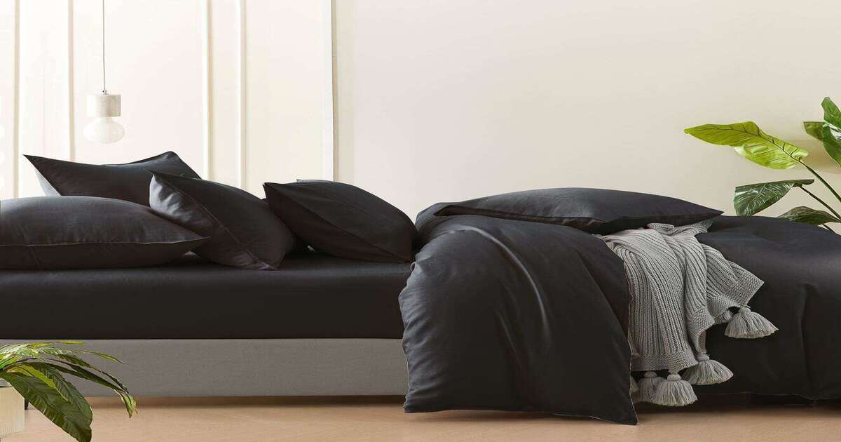 A bed with charcoal bamboo bed sheets and pillow protectors.