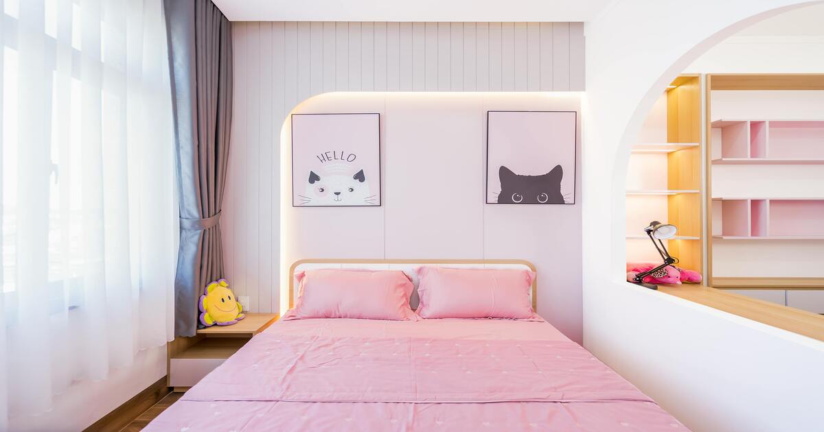 A bedroom with pink flat and fitted sheets on a bed.