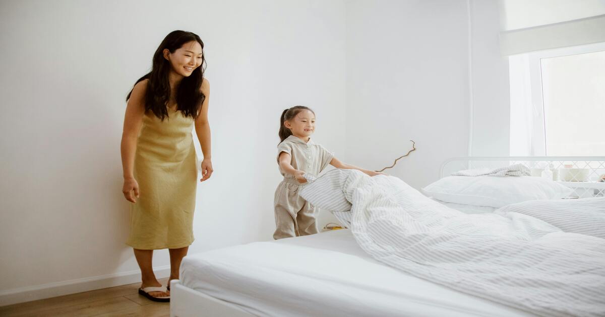 A mother and daughter making a bed and explaining what jersey cotton sheets are.