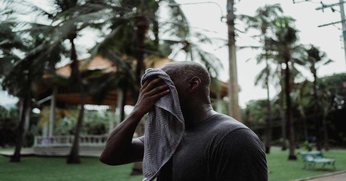 A sweaty person wondering if bamboo sheets are good for hot weather.