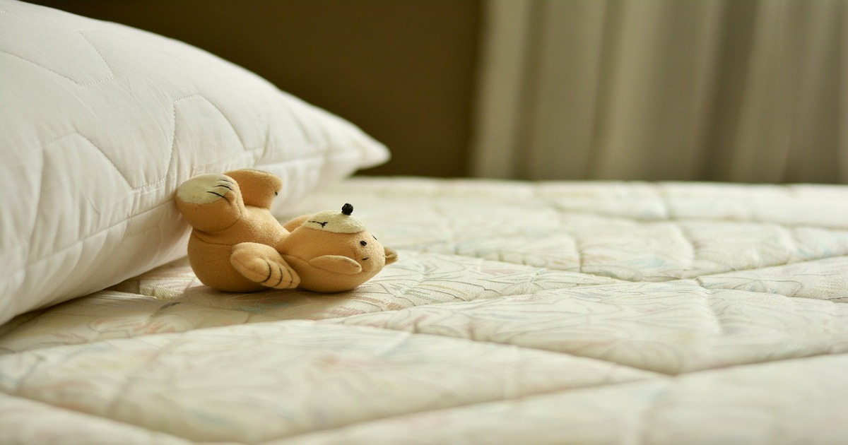 A stuffed toy on a mattress.